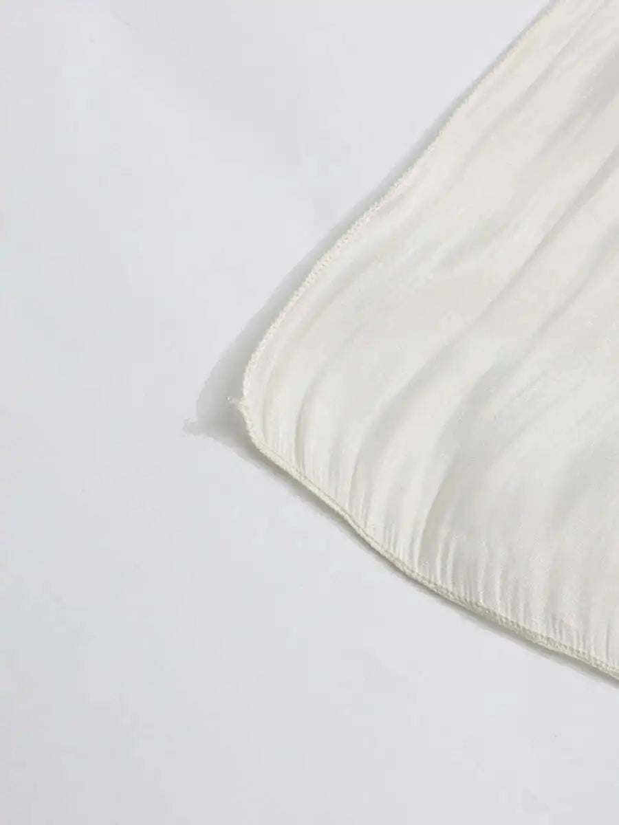 Close-up of a beige textured fabric corner on a white background