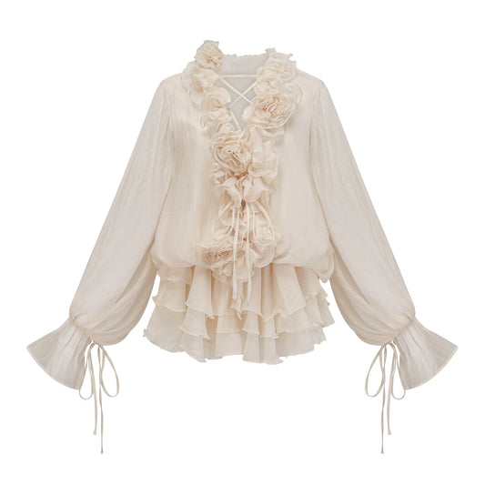 Cream-colored blouse with floral details and long sleeves on a white background
