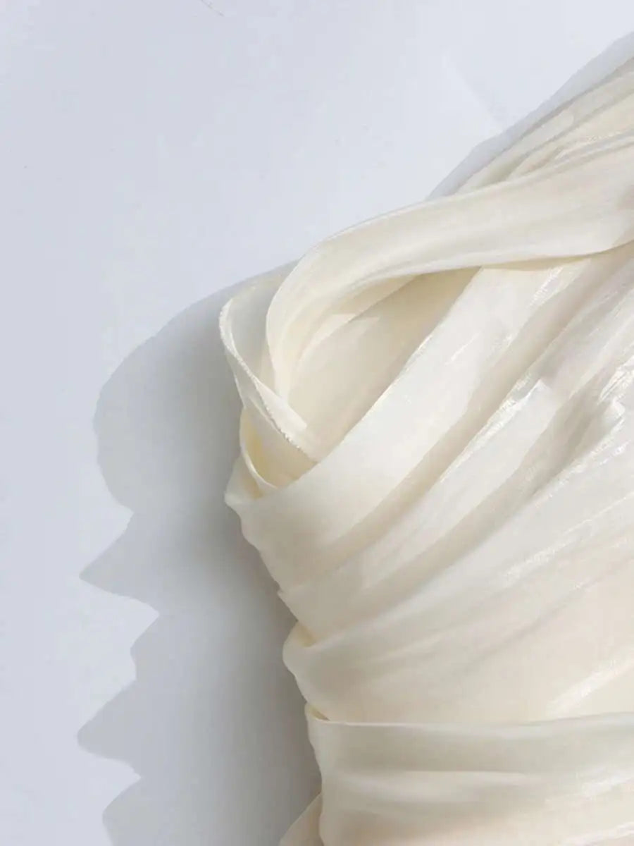 Close-up of a draped white fabric on a white background