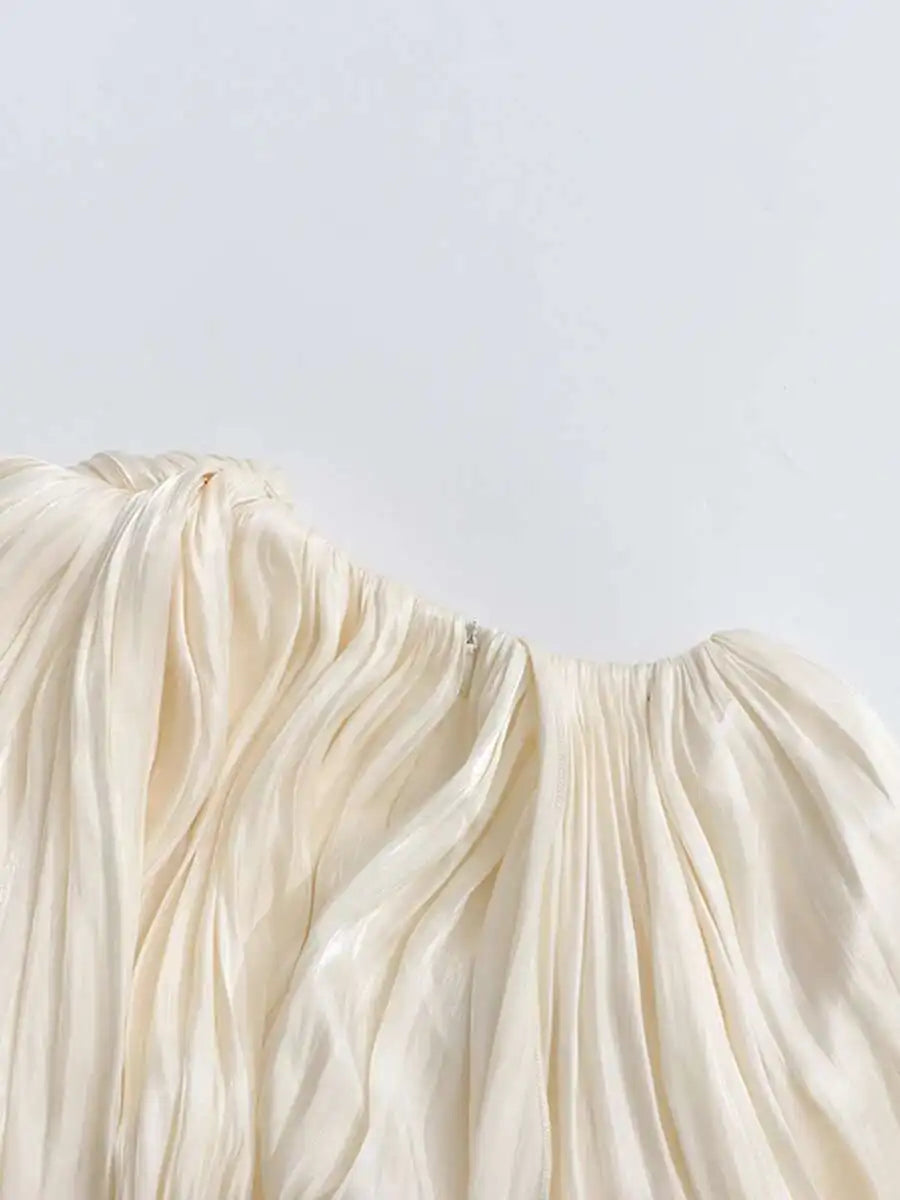 Close-up of a beige-colored fabric with folds on a white background